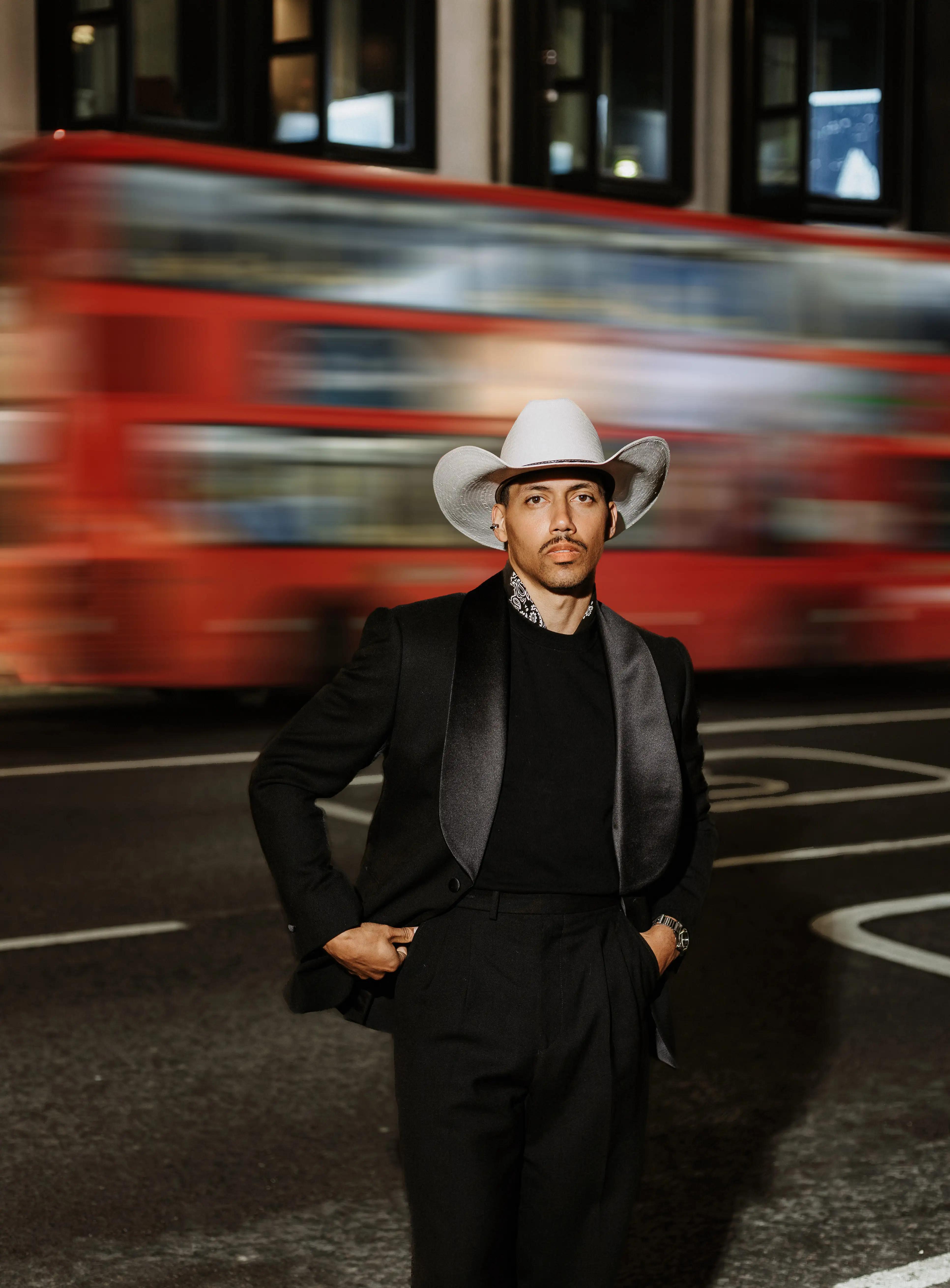 man stands in front of a moving bus