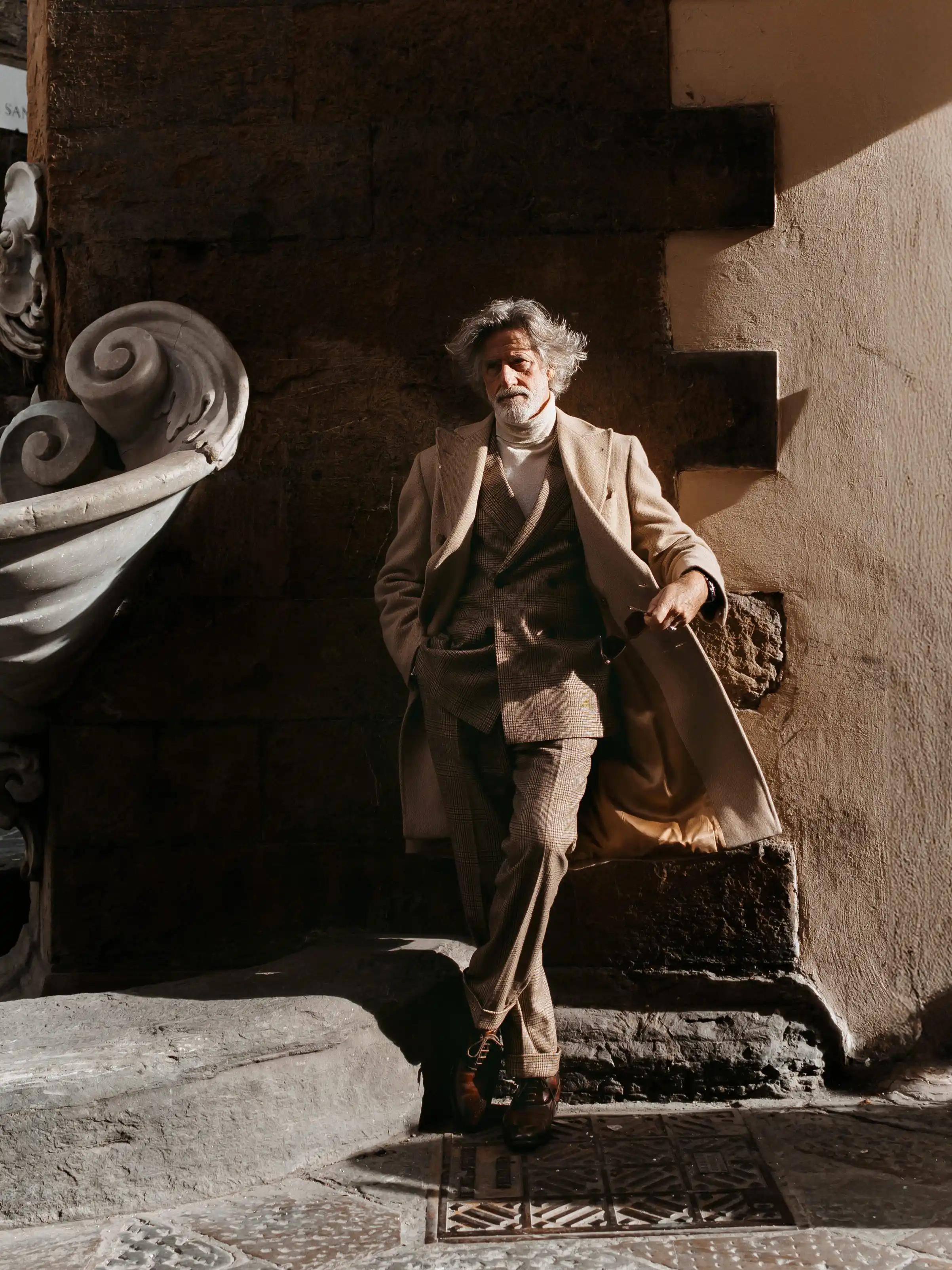 Man in a beige coat and suit stands in Florence